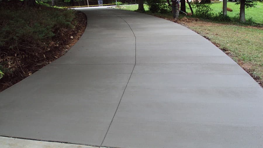 Newly constructed and paved concrete driveway beside a garden in Maimi